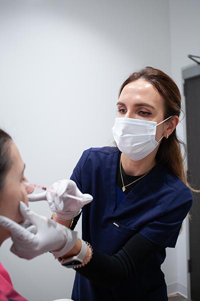 Provider administering dermal filler treatment to support facial contour in Southlake TX.