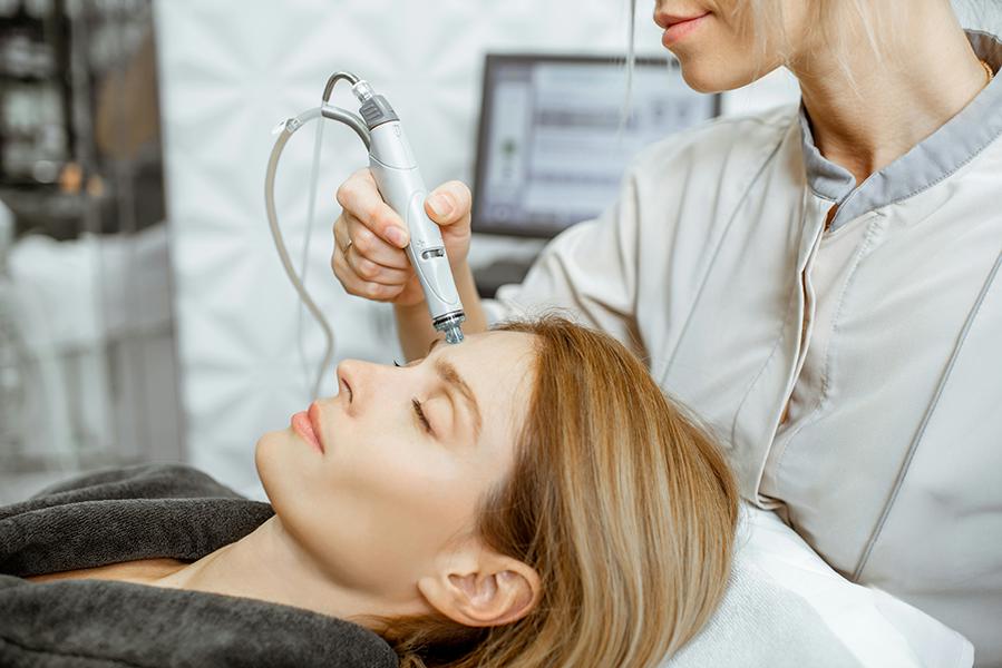 Aesthetic specialist performing an RF microneedling treatment on a client at a medical spa in Southlake Texas