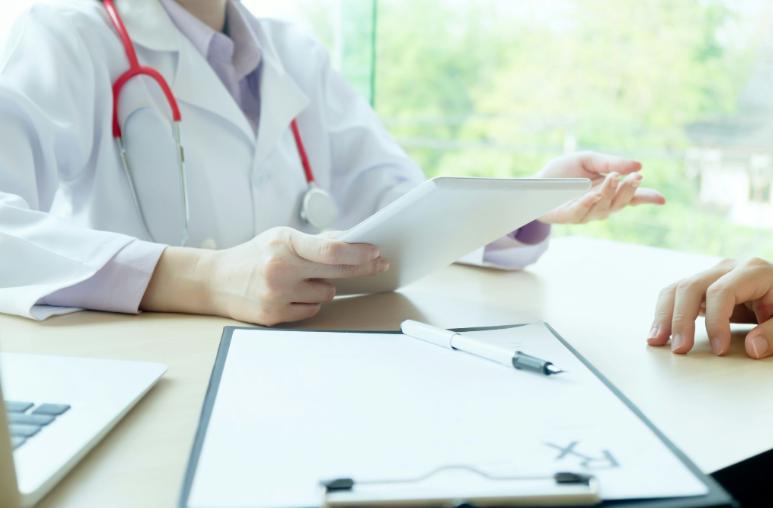 Medical professional consulting with a patient during an initial aesthetic appointment at SVIT Aesthetics, reviewing treatment information on a tablet in a calm clinical setting.