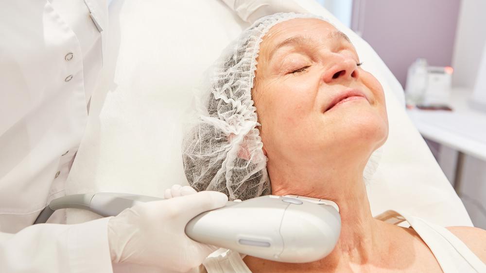 Mature client receiving a skin tightening treatment to improve laxity and facial contour.